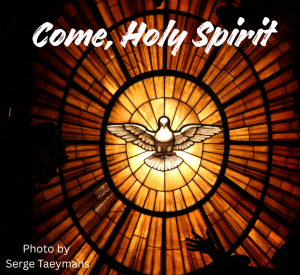 Ovular stained glass window of red, orange, and yellow shades with a dove in the center.
